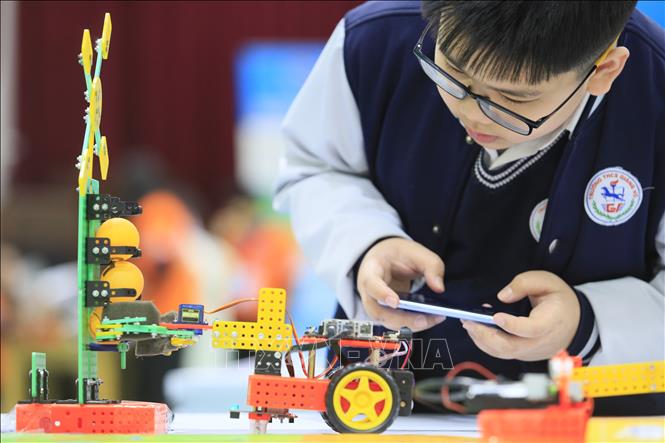 Học sinh trường Trung học cơ sở Giảng Võ điều khiển robot gắp bóng trong cuộc thi Sáng tạo Robotics dành cho học sinh Trung học cơ sở của Hà Nội năm 2024. Ảnh: Trần Hiếu - TTXVN