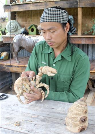 Tạo dáng một con ốc mượn hồn hay còn gọi là cua ẩn sĩ từ đốt tre. Ảnh: Thanh Tân - TTXVN