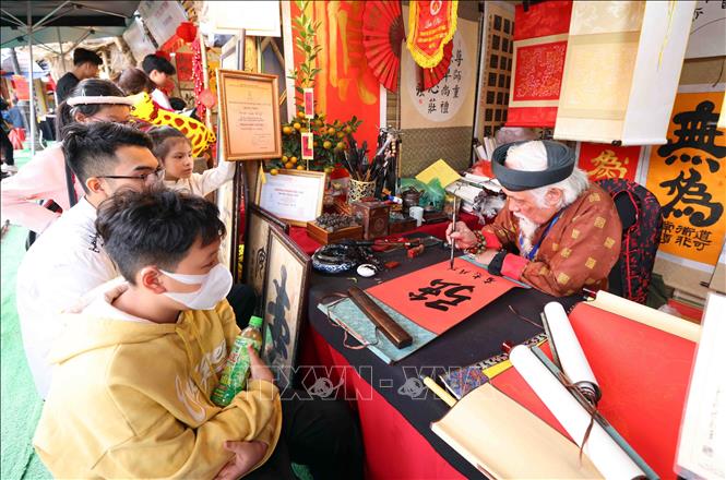 Xin chữ đầu năm tại khu di tích Văn Miếu - Quốc Tử Giám với ước vọng con cái học hành, thi cử đỗ đạt và gặp nhiều may mắn cũng là nét đẹp truyền thống của người dân Thủ đô mỗi dịp du Xuân. Ảnh: Phạm Kiên - TTXVN