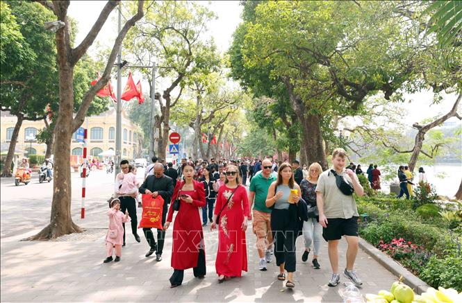 Du khách trong nước và quốc tế thảnh thơi du xuân bên hồ Hoàn Kiếm trong ngày mùng 3 Tết Nguyên đán Ất Tỵ 2025. Ảnh: Phạm Kiên - TTXVN