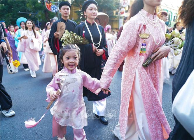Một em nhỏ thích thú tham gia diễu hành tại cổ phục Việt tại Bách hoa bộ hành 2024. Ảnh: Khánh Hoà - TTXVN