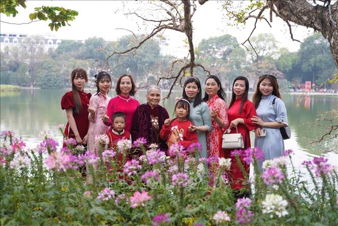 Các thế hệ trong gia đình chọn trang phục truyền thống áo dài để du Xuân dịp Tết Ất Tỵ 2025. Ảnh: Khánh Hoà - TTXVN