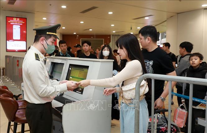 People queue up for security check points at Noi Bai International Airport. VNA Photo: Quốc Khánh 