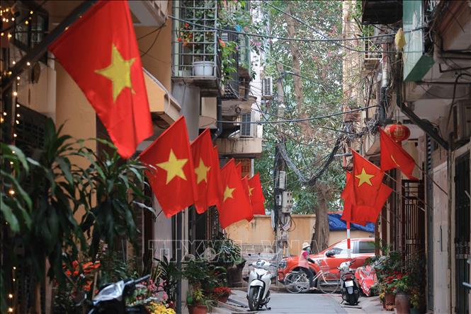 In the small alleys of Hanoi, people put up the national flags to celebrate the 95th anniversary of the founding of the Communist Party of Vietnam. VNA Photo: Hoàng Hiếu