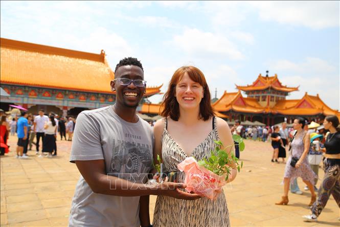 Chị Leryke người Nam Phi cùng hai cây lộc mua tại lễ hội Tết Nguyên đán ở chùa Nam Hoa. Ảnh: Hồng Minh - p/v TTXVN tại Pretoria, Nam Phi