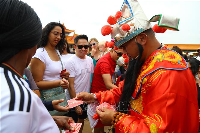 Thần Tài trong dân gian của người châu Á phát bùa bình an cho du khách. Ảnh: Hồng Minh - p/v TTXVN tại Pretoria, Nam Phi