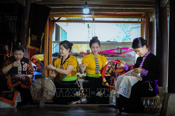 Những phụ nữ dân tộc Thái thêu trang phục dân tộc. Ảnh: Xuân Tư – TTXVN