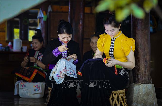 Thiếu nữ dân tộc Thái thêu trang phục truyền thống. Ảnh: Xuân Tư – TTXVN