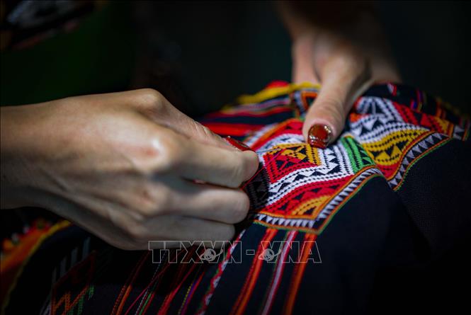 Thêu các họa tiết hoa văn trên chiếc khăn Piêu. Ảnh: Xuân Tư – TTXVN