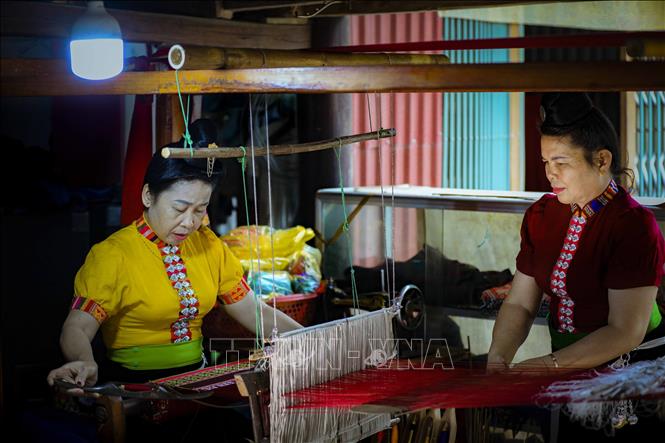 Nghệ nhân Quàng Thị Tâm và Quàng Thị Dinh ở phường Nam Thanh, thành phố Điện Biên Phủ dệt thổ cẩm trang phục truyền thống dân tộc Thái. Ảnh: Xuân Tư – TTXVN