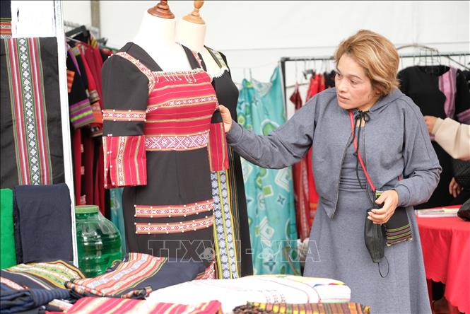 Bà Ka Hờn, chủ nhà may Hờn tại xã Liên Đầm (Di Linh, Lâm Đồng) bên bộ váy thổ cẩm cách tân. Ảnh: Nguyễn Dũng – TTXVN