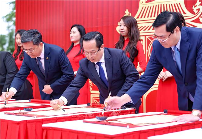 Các đại biểu thực hiện nghi thức khai bút Xuân Ất Tỵ. Ảnh: Thanh Tùng - TTXVN