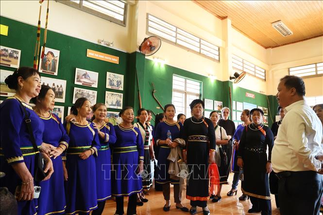 Phó Chủ tịch UBND xã Tà Lài Đặng Sơn Lâm (áo trắng) giới thiệu những nét văn hóa bản địa cho khách tham quan Phòng truyền thống xã Tà Lài. Ảnh: Hồng Đạt - TTXVN
