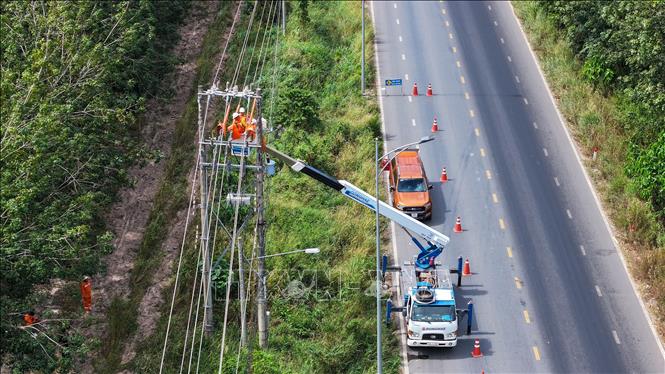 Công tác trên lưới điện của Đội thi công sửa chữa điện nóng (Hotline) dưới cái nắng nóng gay gắt ở vùng biên thuộc huyện Tân Châu, tỉnh Tây Ninh. Ảnh: Thanh Tân - TTXVN