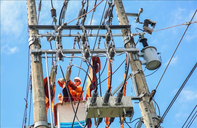 Đội thi công sửa chữa điện nóng (Hotline) thực hiện công tác thay thế một thiết bị điện. Ảnh: Giang Phương - TTXVN