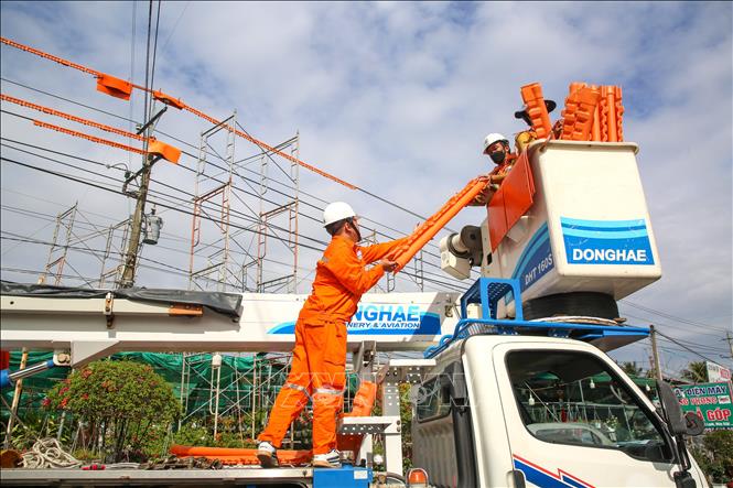 Công tác chuẩn bị trước khi lên lưới điện của Đội thi công sửa chữa điện nóng Điện lực Tây Ninh. Ảnh: Giang Phương - TTXVN