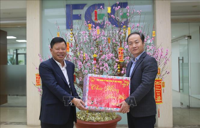 Ông Lê Trung Kiên, Trưởng ban Ban quản lý Khu kinh tế Hải Phòng (bên trái) tặng quà Lãnh đạo Công ty TNHH Flat Việt Nam. Ảnh: Minh Thu - TTXVN