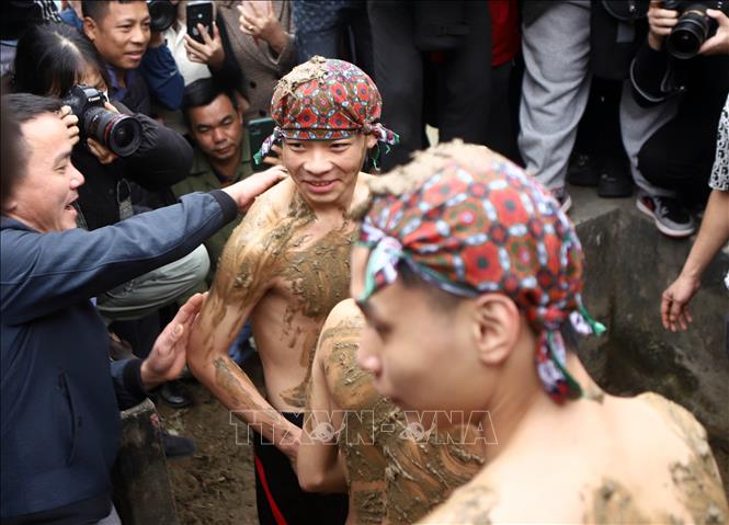 Sau khi tắm, các “Bụt” được rước đi thực hiện nghi thức trát bùn. Ảnh: Hoàng Hùng - TTXVN