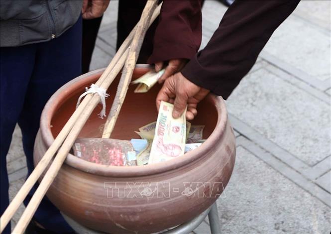 Người dân cúng tiến vào chậu sành để thực hiện nghi thức tắm “ông Bụt” với tương truyền sẽ đem lại may mắn, tài lộc. Ảnh: Hoàng Hùng - TTXVN