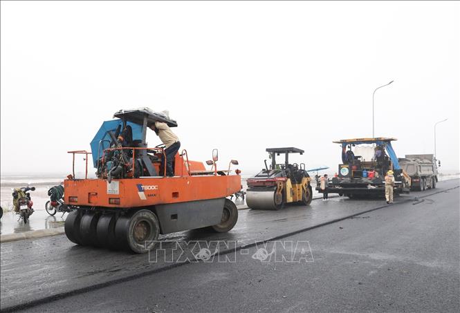 Công nhân chuẩn bị xe máy để trải bê tông nhựa asphalt khi thời tiết thuận lợi tại Dự án xây dựng kênh kết hợp đường Vạn Hạnh (giai đoạn I). Ảnh: Đức Phương - TTXVN