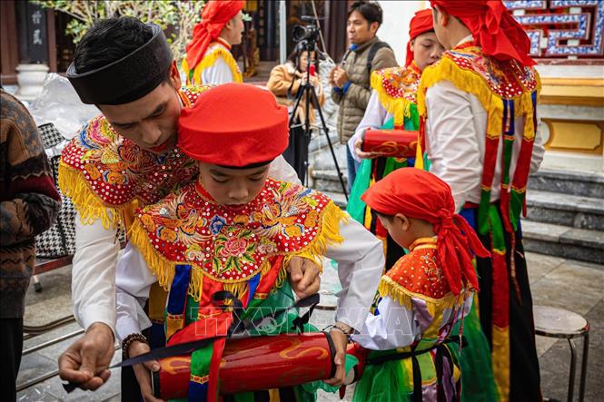 Thành viên CLB trống bồng Triều Khúc hướng dẫn, chuẩn bị trống bồng cho các em nhỏ trước khi tham gia biểu diễn. Ảnh: Phạm Tuấn Anh - TTXVN