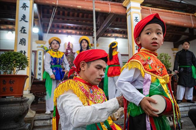 Thành viên CLB trống bồng Triều Khúc hướng dẫn, chuẩn bị trống bồng cho các em nhỏ trước khi tham gia biểu diễn. Ảnh: Phạm Tuấn Anh - TTXVN