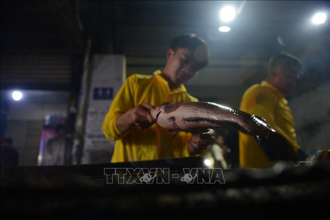 Tối 6/2, phố cá lóc nướng trên đường Tân Kỳ - Tân Quý luôn rực lửa, khói nghi ngút. Ảnh: Mạnh Linh - TTXVN
