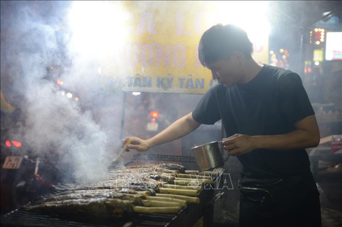 Tối 6/2, phố cá lóc nướng trên đường Tân Kỳ - Tân Quý luôn rực lửa, khói nghi ngút. Ảnh: Mạnh Linh - TTXVN