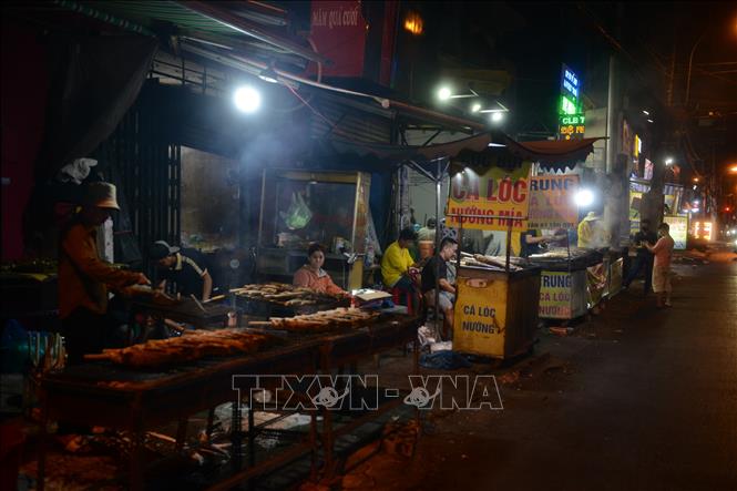 Tối 6/2, phố cá lóc nướng trên đường Tân Kỳ - Tân Quý luôn rực lửa, khói nghi ngút. Ảnh: Mạnh Linh - TTXVN