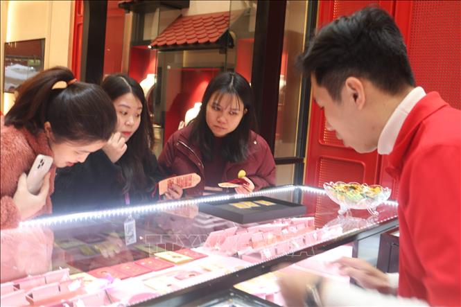 Khách hàng lựa chọn sản phẩm vàng trong ngày vía Thần Tài. Ảnh: Văn Giáp-TTXVN