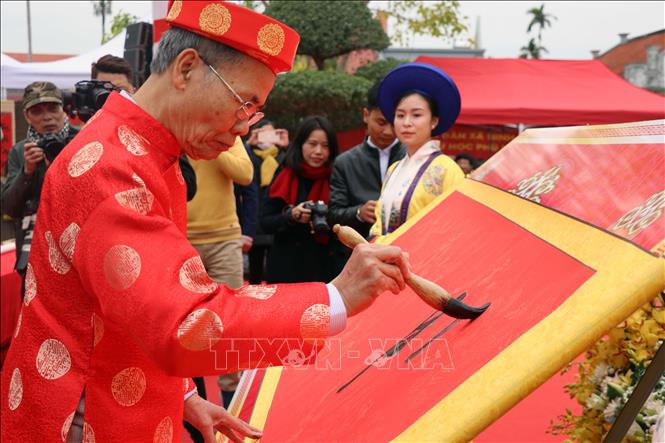 Nhà thư pháp Lê Anh Châu đại diện khai bút tại lễ hội với 4 chữ: Khai Triển Hồng Đồ. Ảnh: Hoàng Ngọc - TTXVN