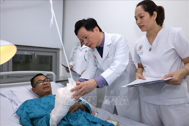 Bác sĩ Hoàng kiểm tra sức khỏe bệnh nhân sau ca mổ ghép tay tại Bệnh viện Trung ương Quân đội 108. Ảnh: Tuấn Anh - TTXVN