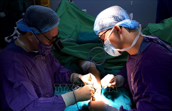 Bác sĩ Hoàng cùng ê kíp thực hiện một ca phẫu thuật ghép tay. Ảnh: Tuấn Anh - TTXVN