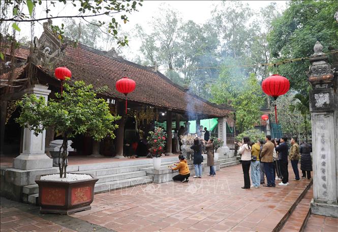 Du khách thắp hương chiêm bái, khấn nguyện trước tòa Thượng điện của Đền Cuông. Ảnh: Xuân Tiến - TTXVN  