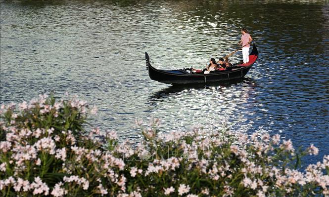 Khách du lịch chèo thuyền trên hồ nước tại Venice, Italy. Ảnh: THX/TTXVN