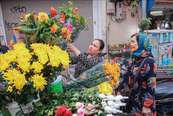 Choosing fresh flowers for offerings. VNA Photo: Hoàng Hiếu