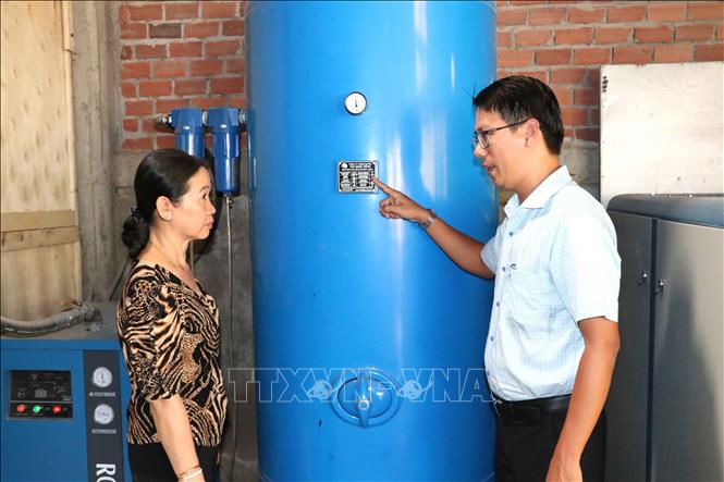 Ông Nguyễn Đăng Khởi, Phó Giám đốc Trung tâm Khuyến công và Xúc tiến thương mại Trà Vinh (phải) nghiệm thu máy nén khí. Ảnh: Thanh Hòa-TTXVN