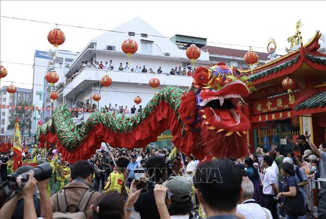 Đoàn diễu hành Lân sư rồng trên tuyến đường Lão Tử (Quận 5) được đông đảo người dân đón xem. Ảnh: Thu Hương - TTXVN