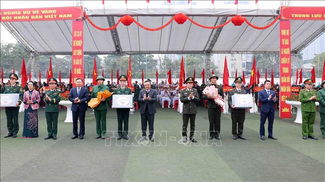 Chủ tịch UBND thành phố Hà Nội Trần Sỹ Thanh và Thượng tướng Lê Quốc Hùng, Thứ trưởng Bộ Công an tặng hoa và quà cho đại diện các tân binh lên đường nhập ngũ. Ảnh: Phạm Kiên - TTXVN