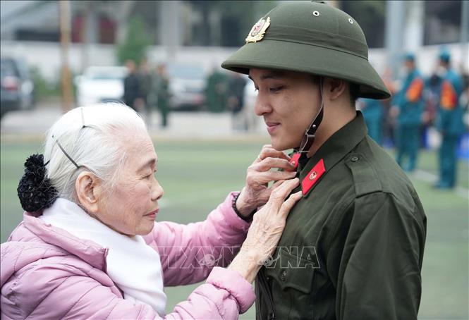Bà Nguyễn Thị Minh Thuận (90 tuổi) tiễn cháu lên đường thực hiện nghĩa vụ Công an nhân dân tại điểm giao, nhận quân Quận Đống Đa, Hà Nội. Ảnh: Phạm Kiên - TTXVN