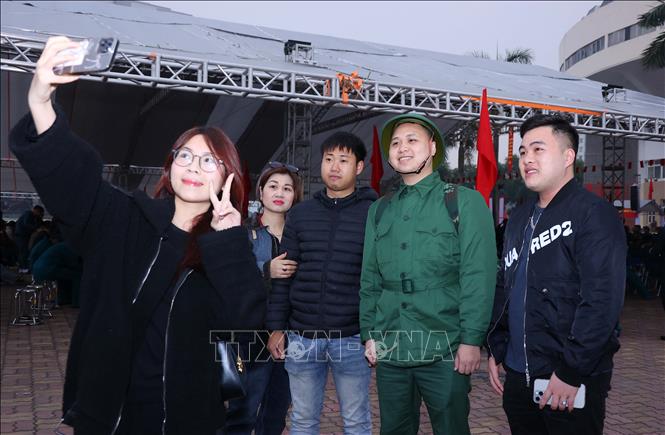 Bạn bè, người thân chụp hình lưu niệm cùng tân binh tại Lễ giao nhận quân Quận Ba Đình. Ảnh: Văn Điệp - TTXVN