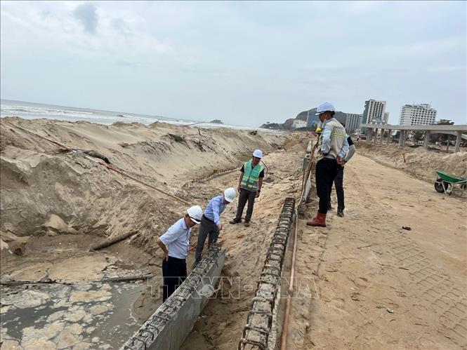 Phó Chủ tịch UBND thành phố Vũng Tàu Nguyễn Trọng Thụy kiểm tra, chỉ rõ lớp bê tông bảo vệ cốt thép kè biển không đủ độ dày và yêu cầu làm lại. Ảnh: Đoàn Mạnh Dương-TTXVN