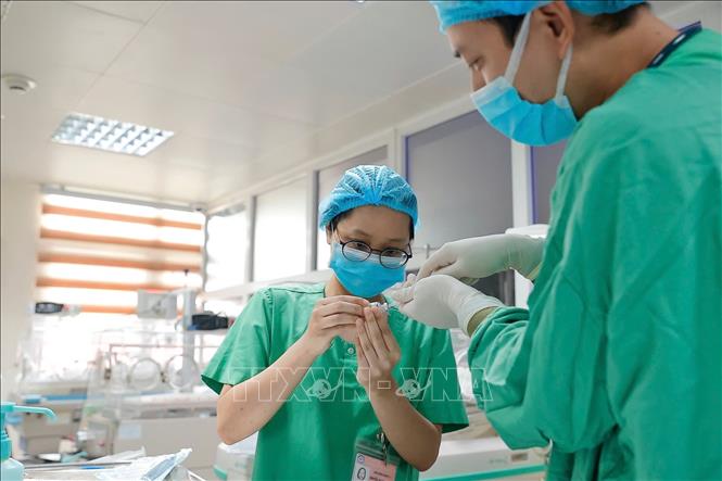 Bác sĩ chuẩn bị bơm surfactant không xâm lấn cho bệnh nhi. Ảnh: Minh Quyết - TTXVN