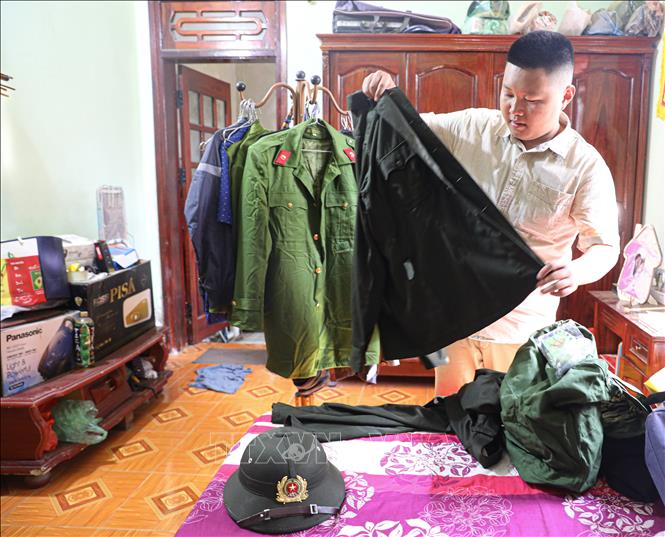 Tân binh Mùa Huy Tuấn chuẩn bị tư trang trước ngày lên đường nhập ngũ. Ảnh: Phan Quân - TTXVN