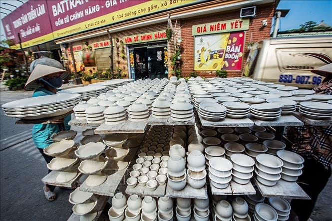 Người dân làng cổ Bát Tràng vận chuyển sản phẩm gốm trên đường, một hình ảnh rất quen thuộc với du khách khi tới thăm quan. Ảnh: Trọng Đạt - TTXVN