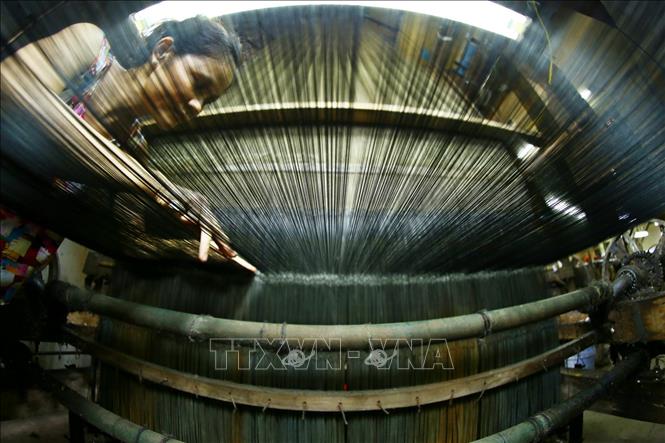 Để làm nên những sản phẩm tơ lụa đặc sắc, người thợ ở làng lụa Vạn Phúc xưa nay đều phải thực hiện một quy trình sản xuất công phu bao gồm nhiều khâu như: tơ, hồ sợi, dệt, nhuộm, căng phơi... Ảnh: Minh Quyết – TTXVN