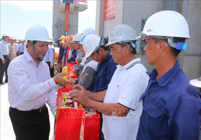 Chủ tịch UBND tỉnh Sóc Trăng Trần Văn Lâu tặng quà cho công nhân trên công trường. Ảnh: Tuấn Phi-TTXVN 