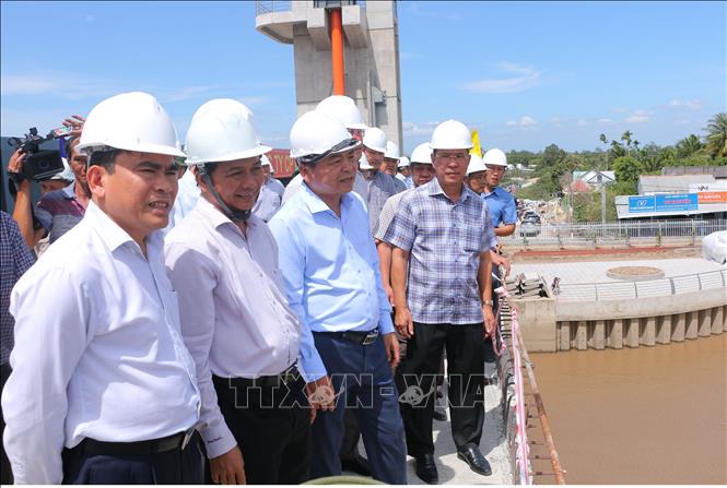 Lãnh đạo Bộ Nông nghiệp và Phát triển nông thôn và UBND tỉnh Sóc Trăng đi khảo sát vận hành cống. Ảnh: Tuấn Phi- TTXVN 