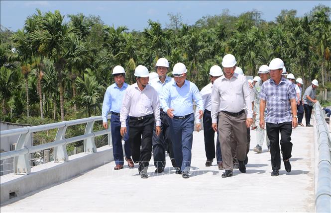 Lãnh đạo Bộ Nông nghiệp và Phát triển nông thôn và UBND tỉnh Sóc Trăng đi khảo sát vận hành cống. Ảnh: Tuấn Phi-TTXVN 