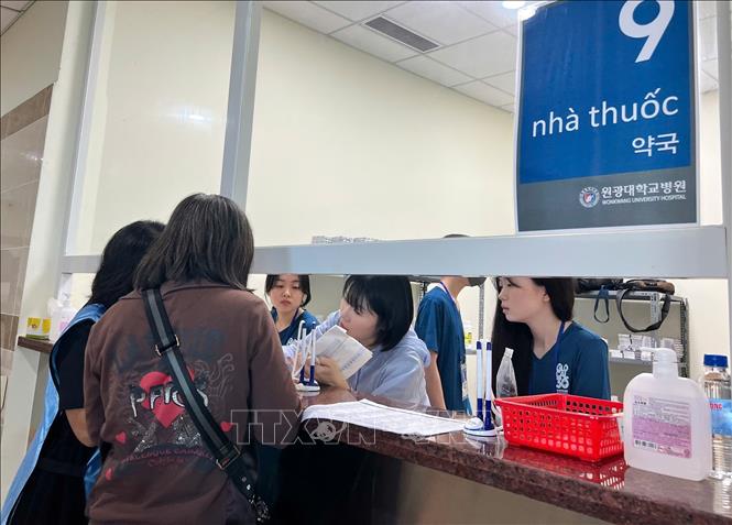 Người dân được hướng dẫn nhận thuốc miễn phí. Ảnh: Ánh Tuyết - TTXVN